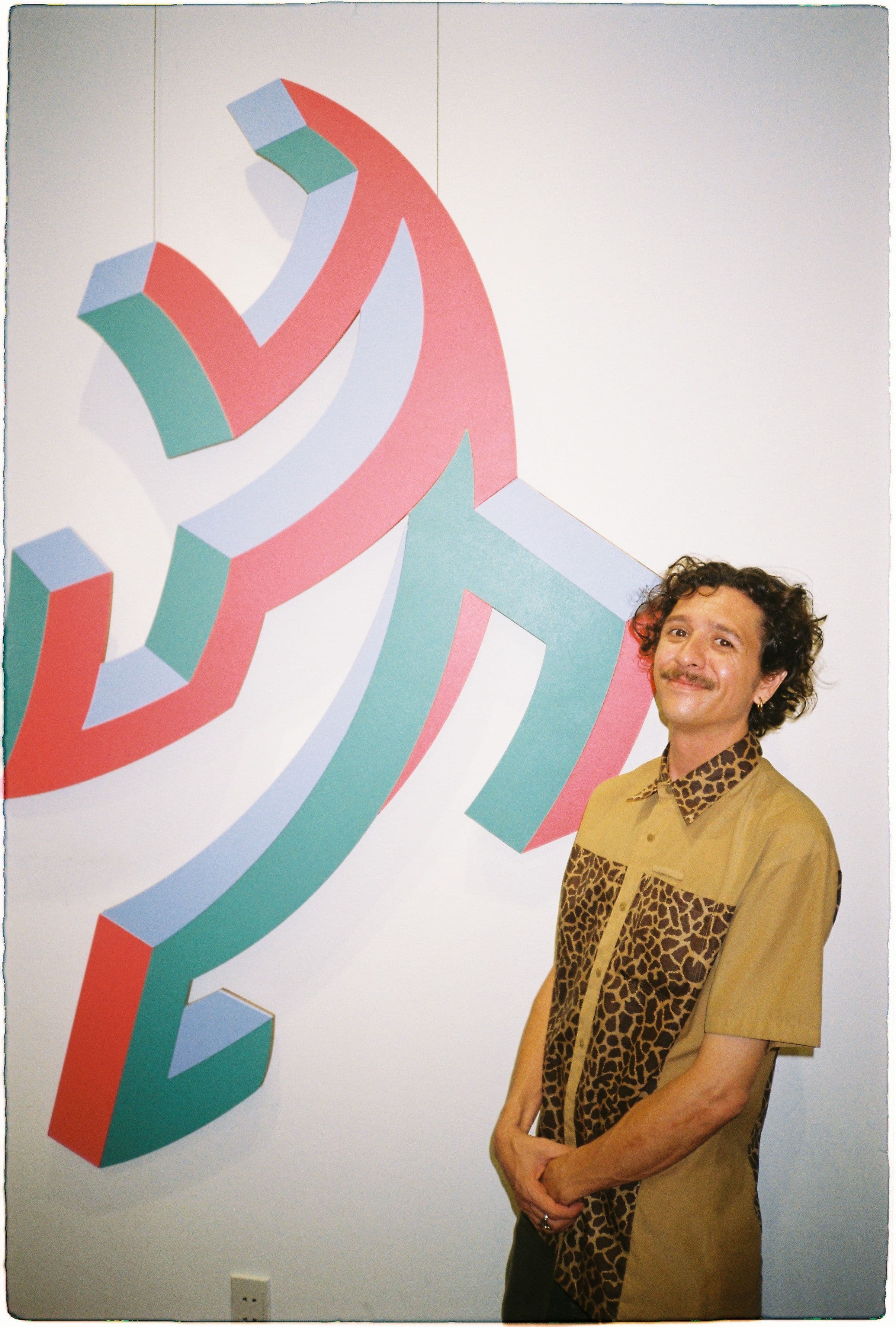 dano standing next to his art 