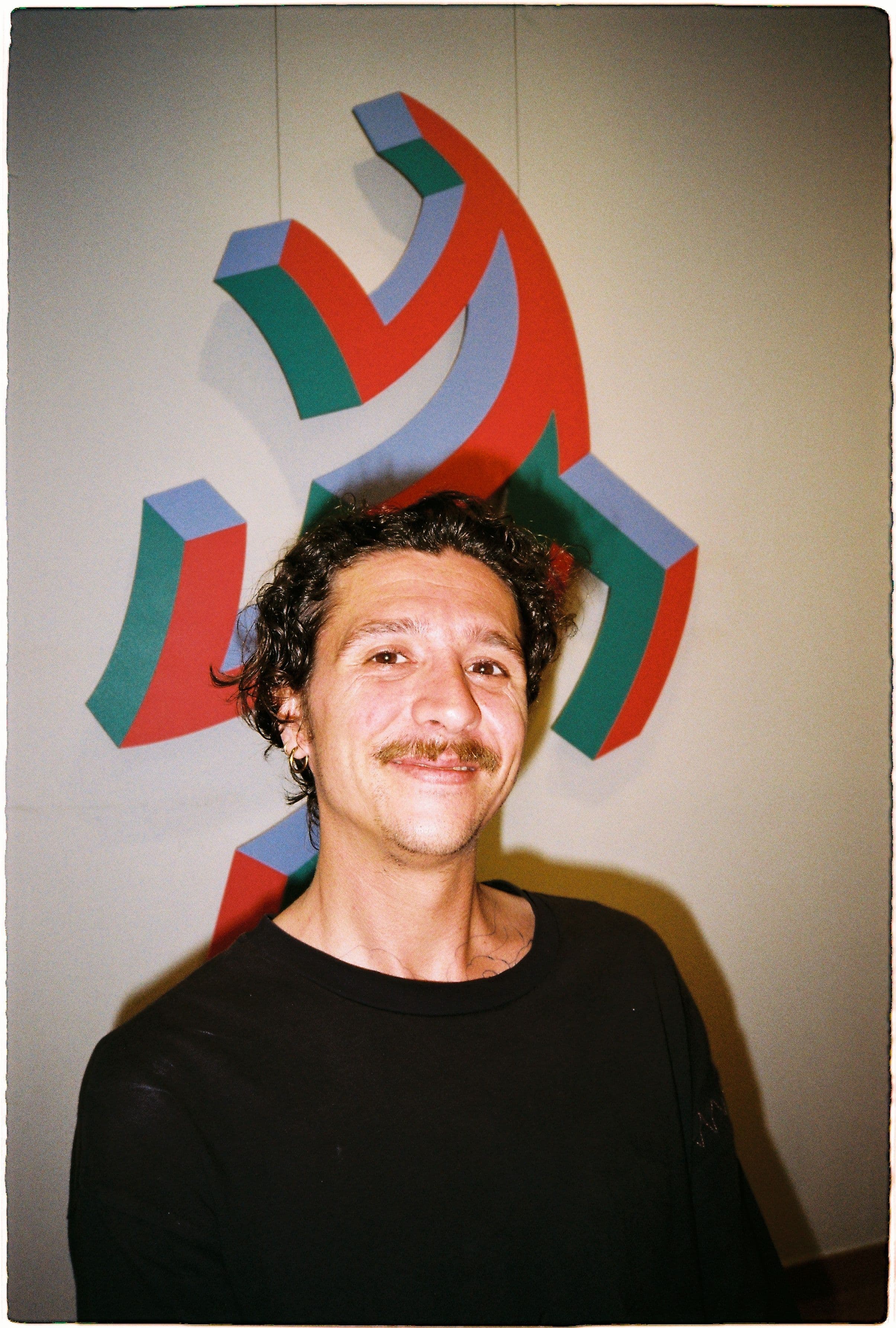 Dano sitting in front his art